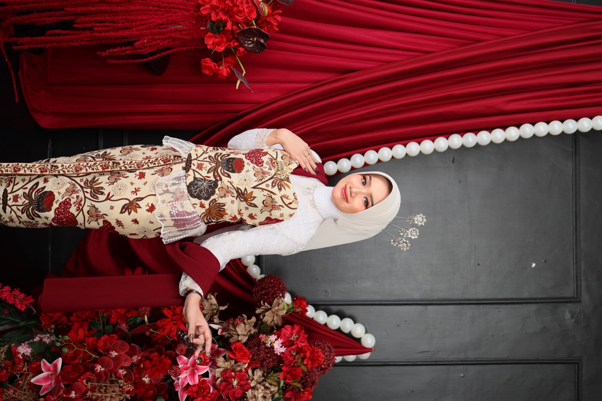 Elvi mengenakan busana adat Jawa bernuansa burgundy